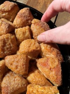 close up of a hand pulling a part a piece of monkey bread